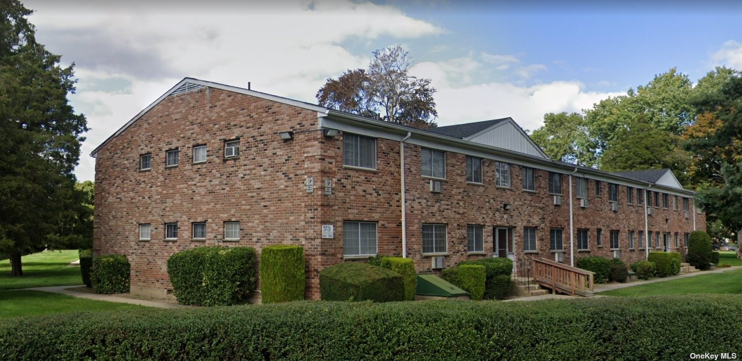 a view of a house with brick walls and a yard with plants