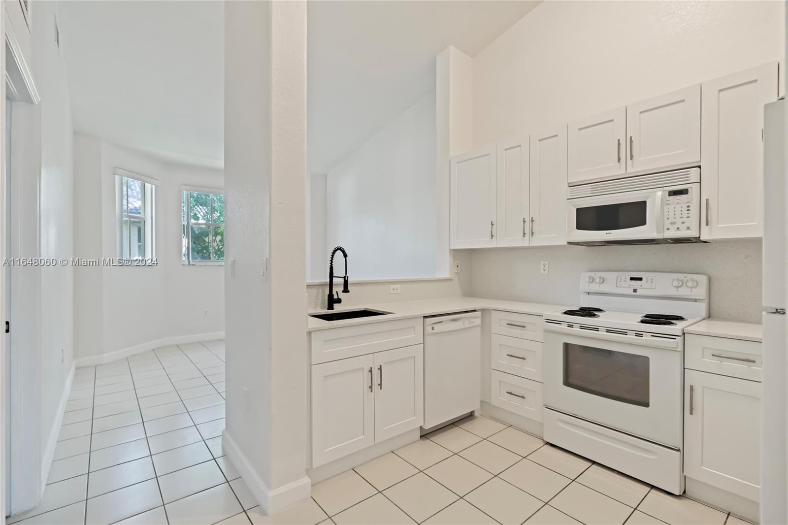 a kitchen with white cabinets appliances and a sink