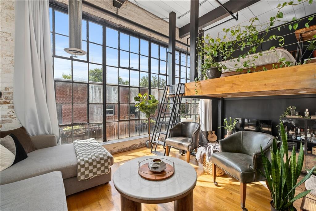 a living room with furniture a rug and a floor to ceiling window