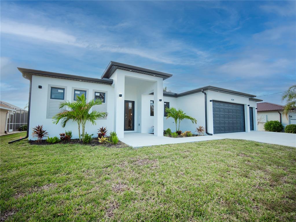 a view of a house with a yard and a garage