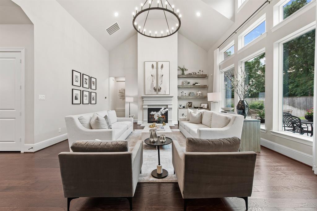 a living room with furniture a fireplace and a floor to ceiling window