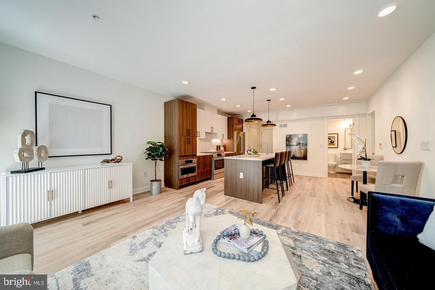 a living room with furniture a kitchen view and a fireplace