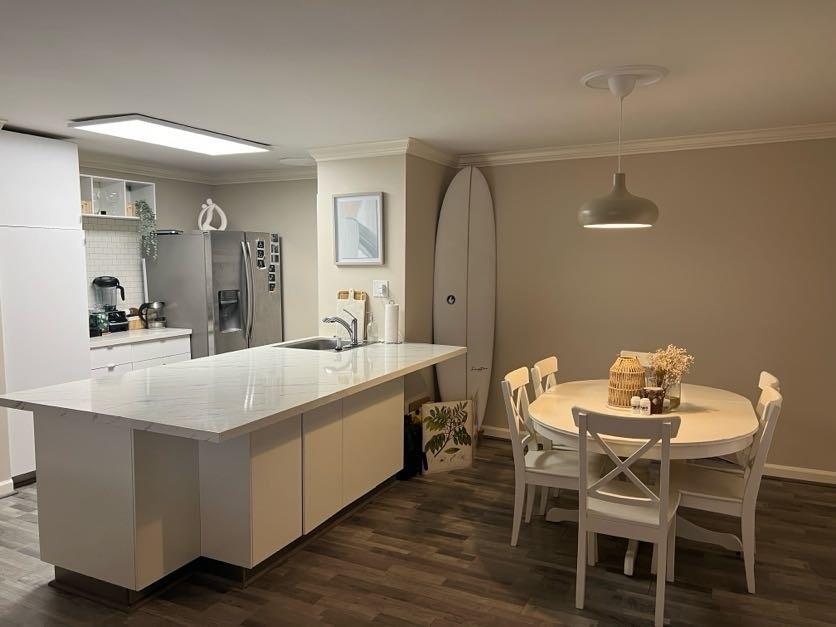 a kitchen with a dining table chairs and white cabinets