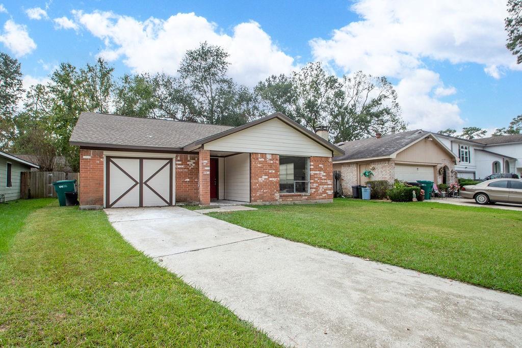 a front view of a house with a yard and trees