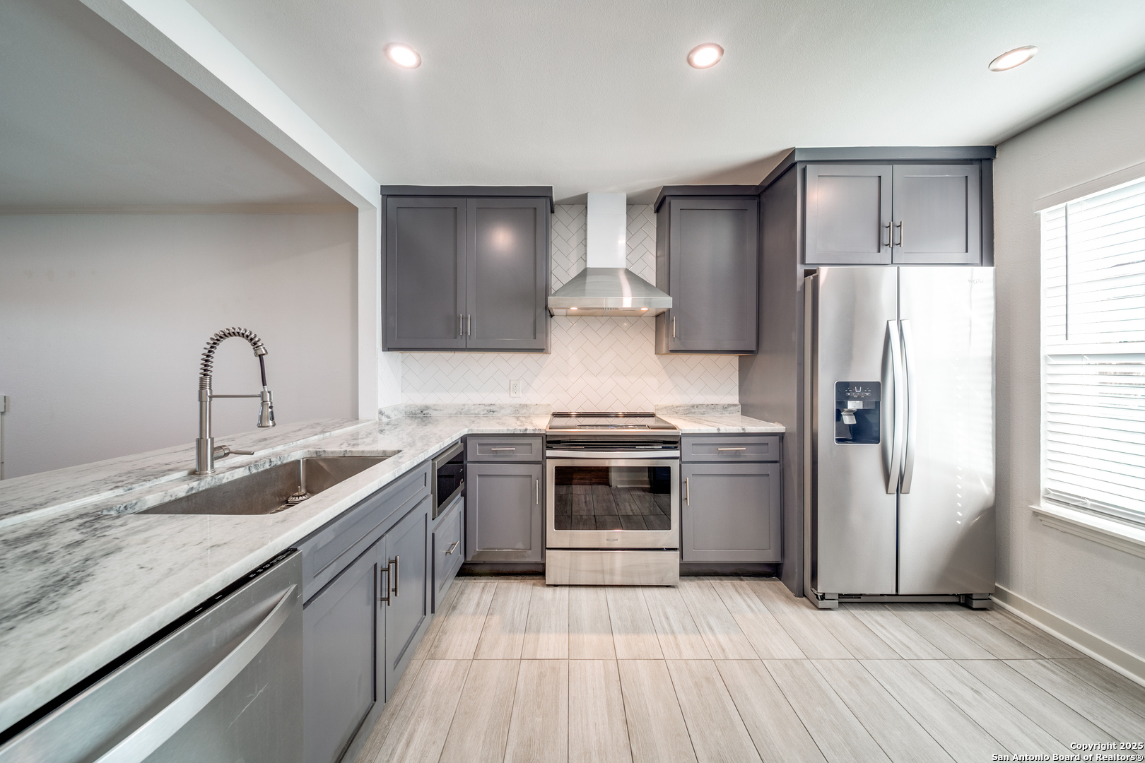 a kitchen with stainless steel appliances granite countertop a sink stove and refrigerator