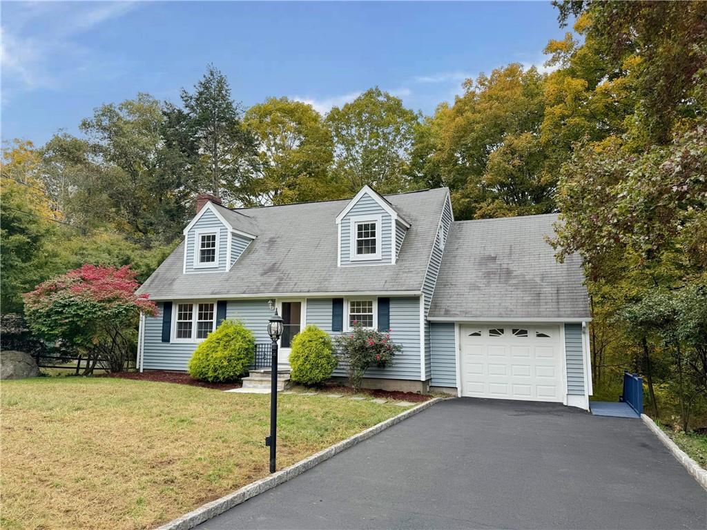 Cape cod-style house with a front yard and a garage