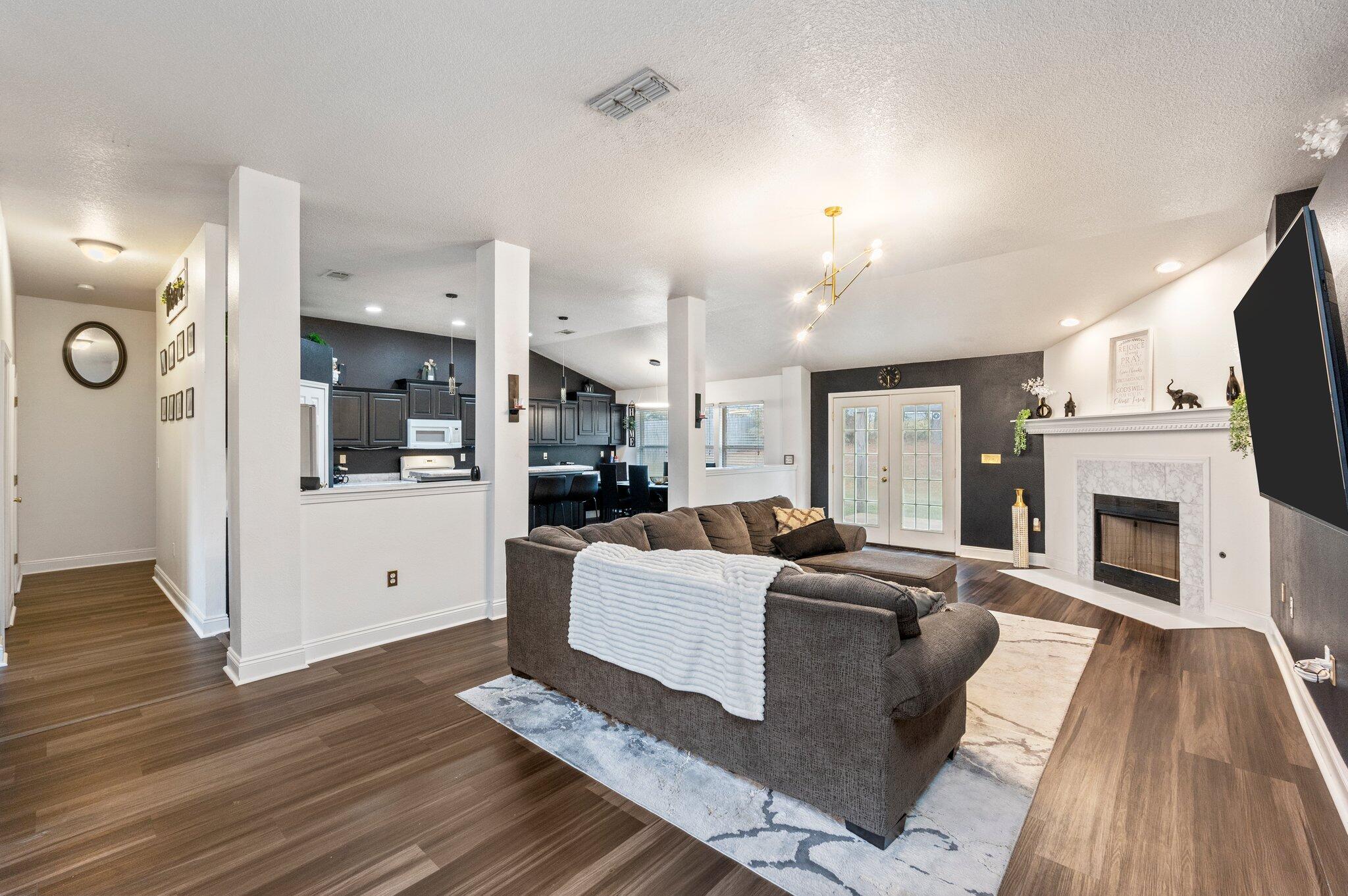 a living room with furniture a fireplace and a flat screen tv