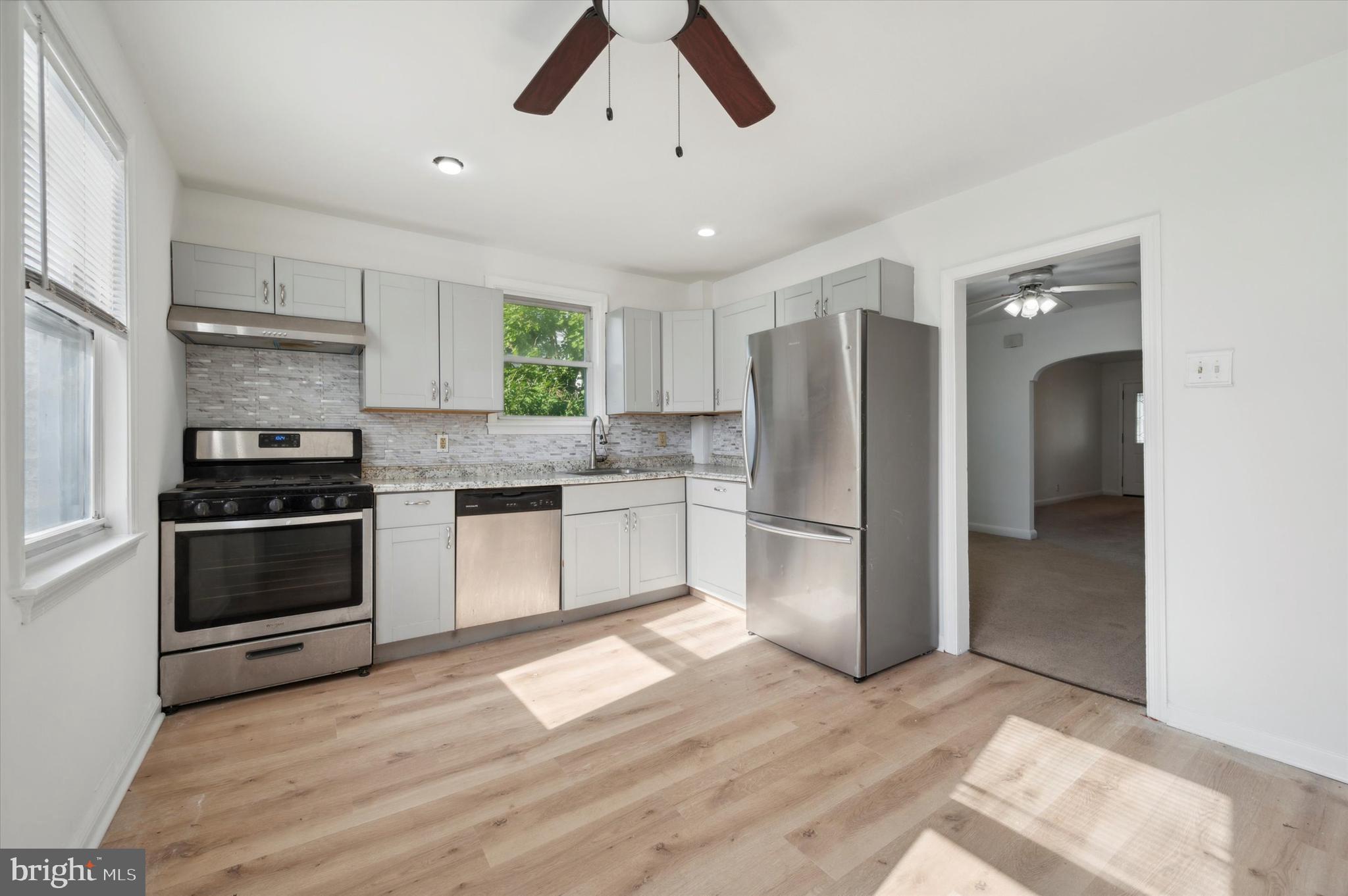 a kitchen with a refrigerator and a stove top oven