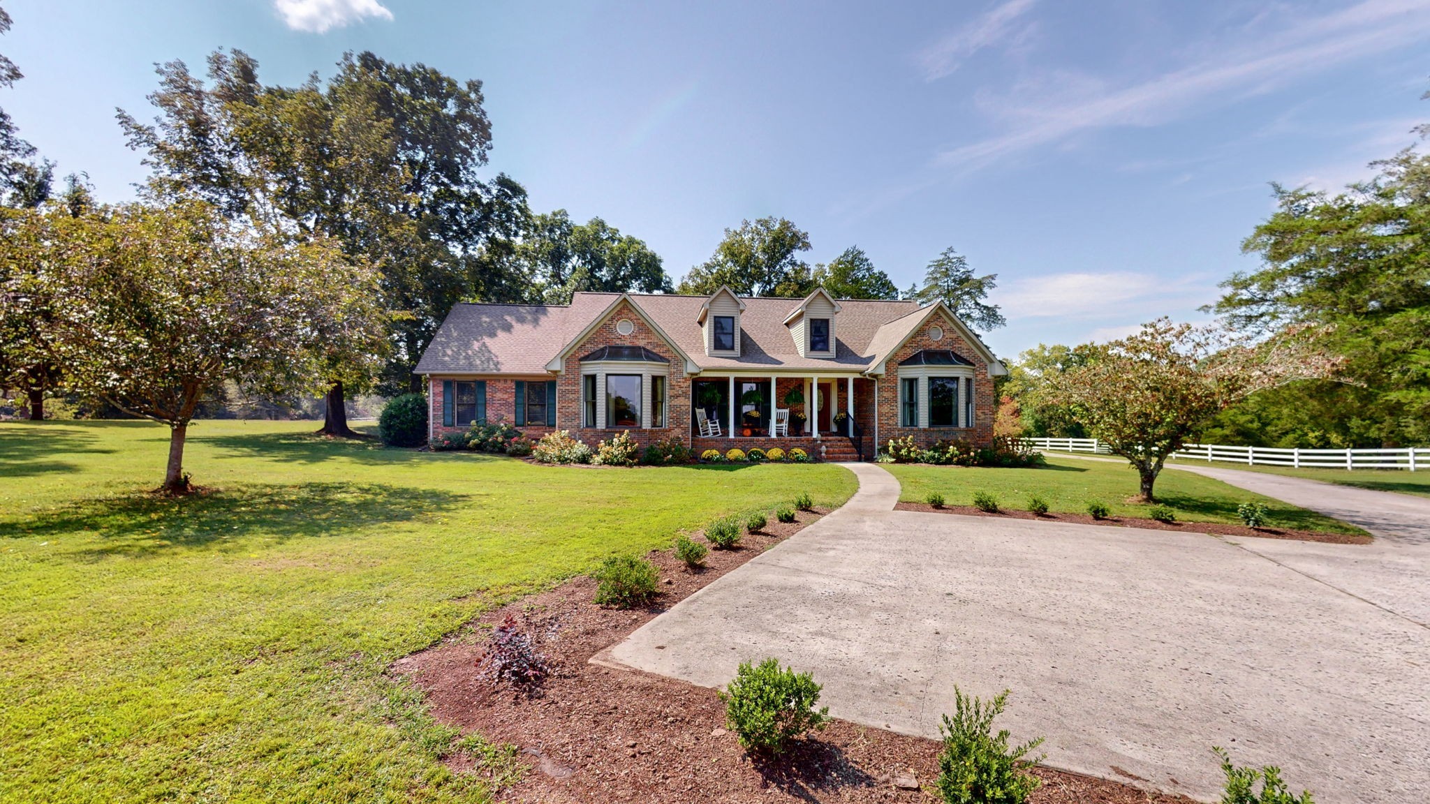 a front view of house with yard and green space