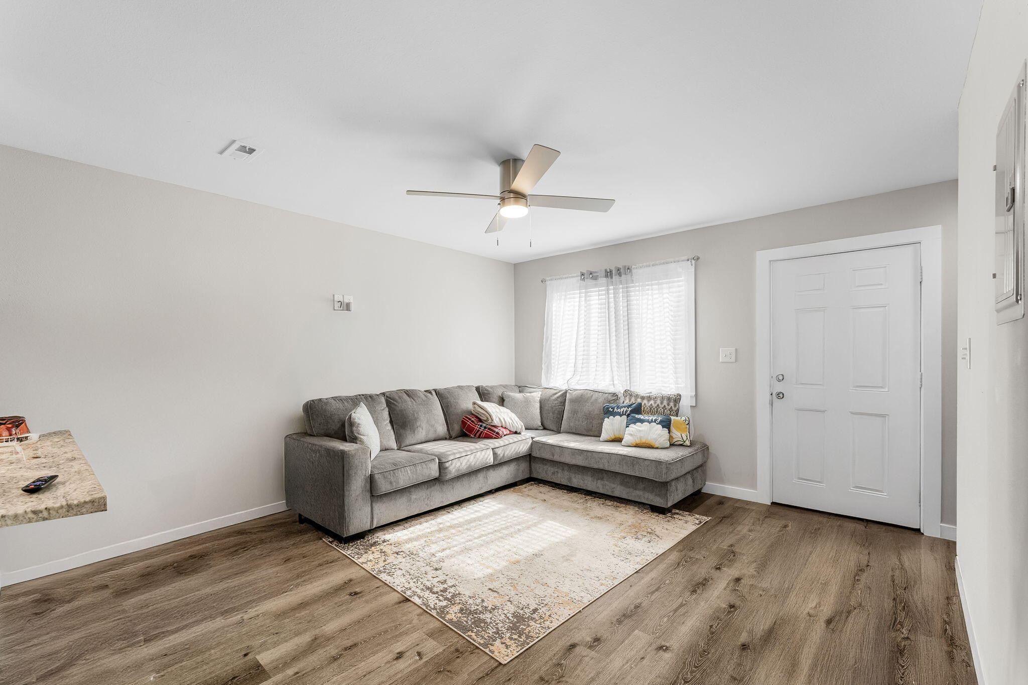 a living room with furniture and a wooden floor