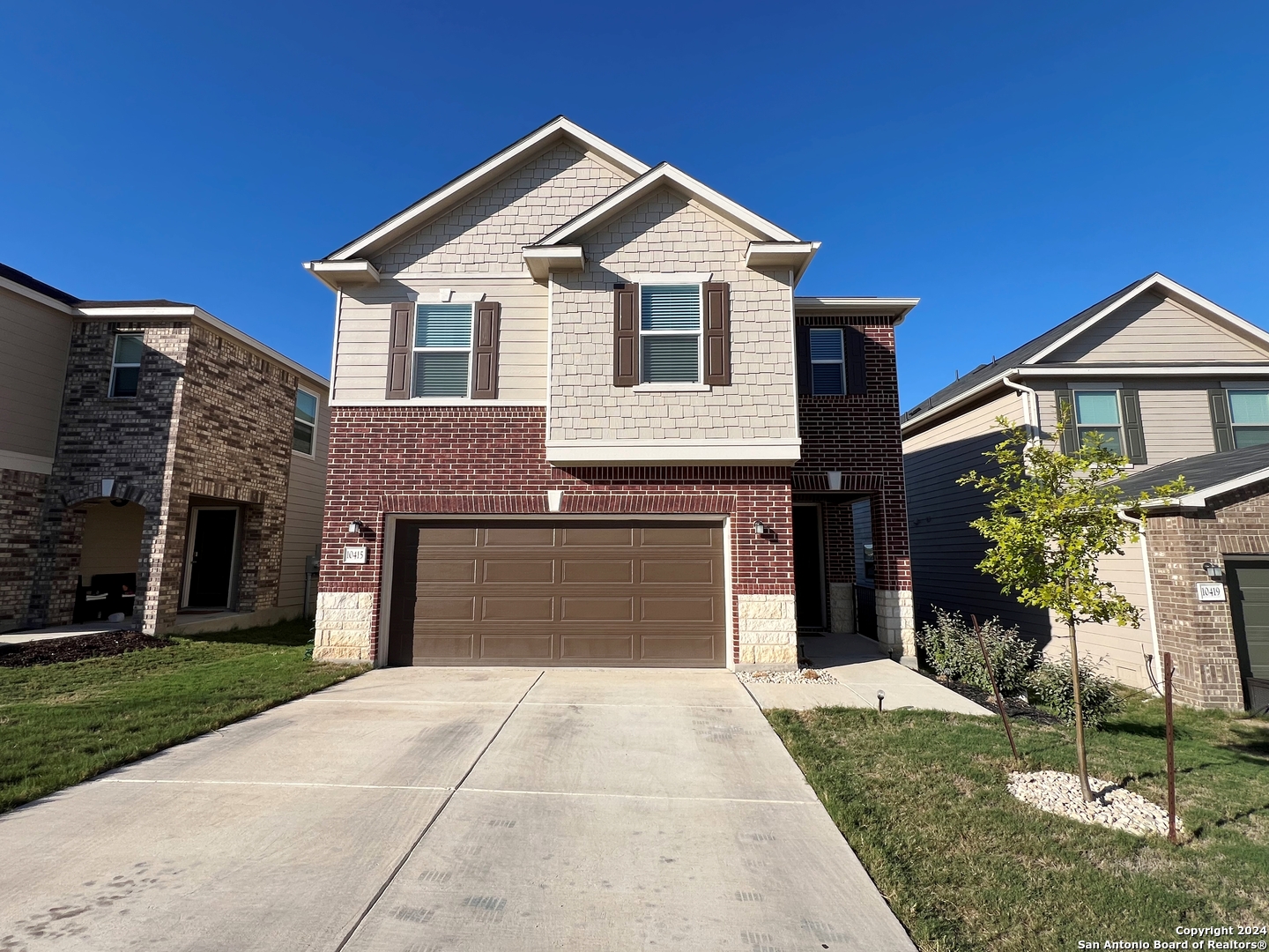 a front view of a house with a yard and garage