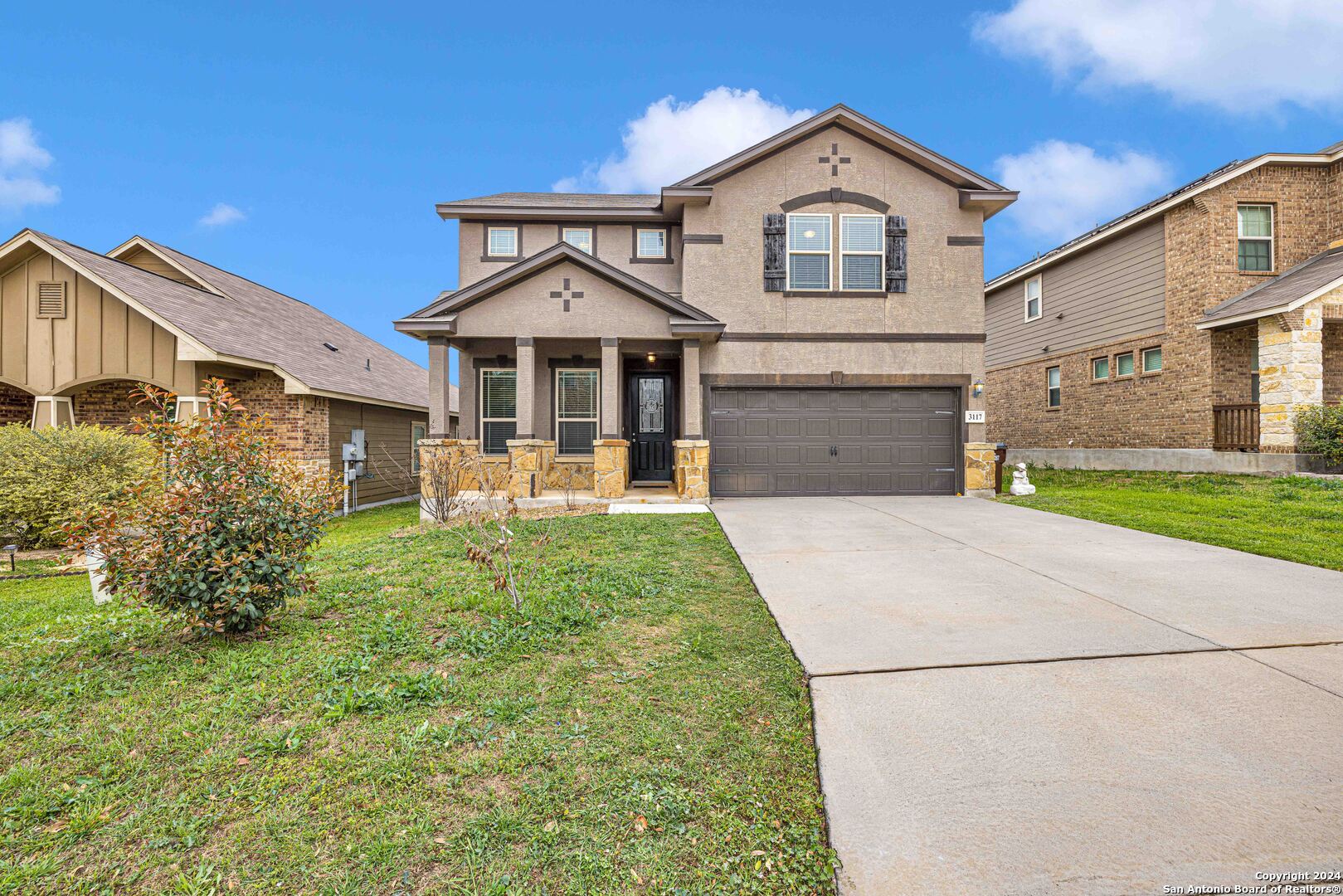 a front view of a house with a yard and garage