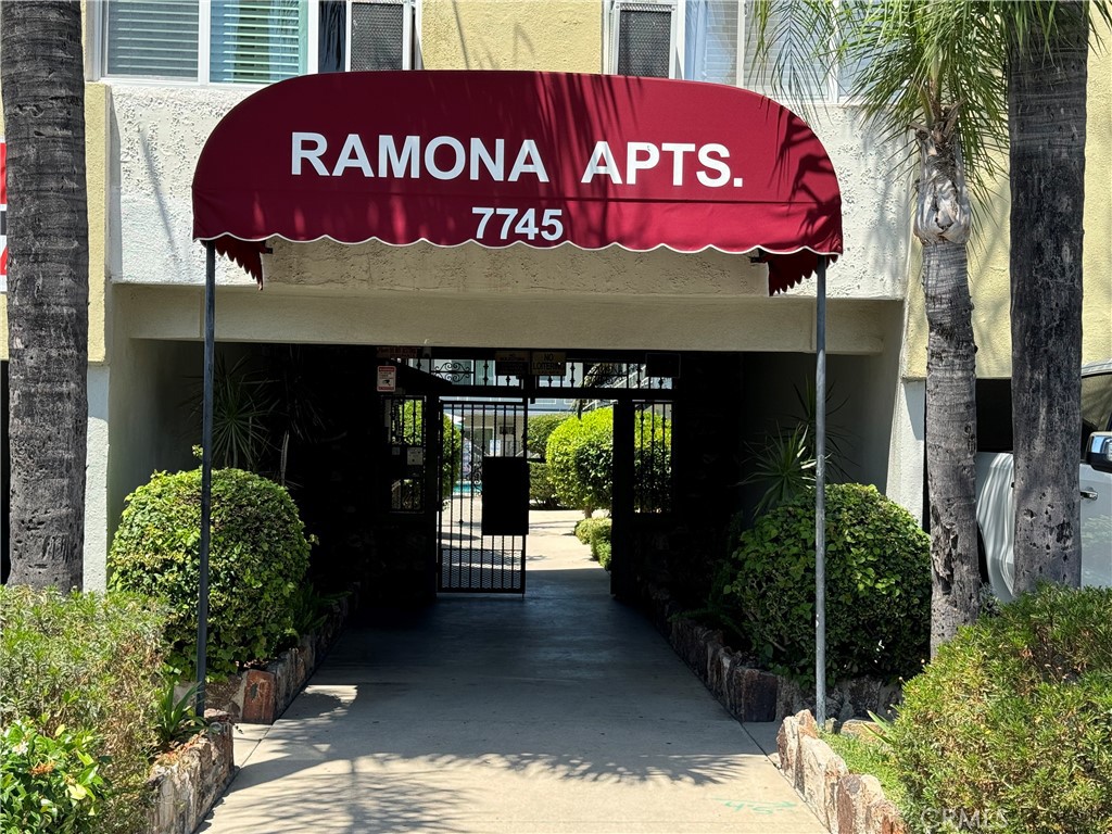 a front view of a building with street and sign board