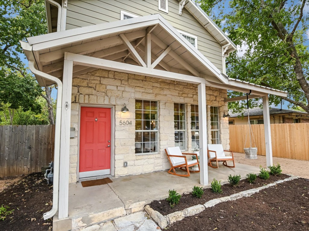 a front view of a house with a chairs and table in a patio