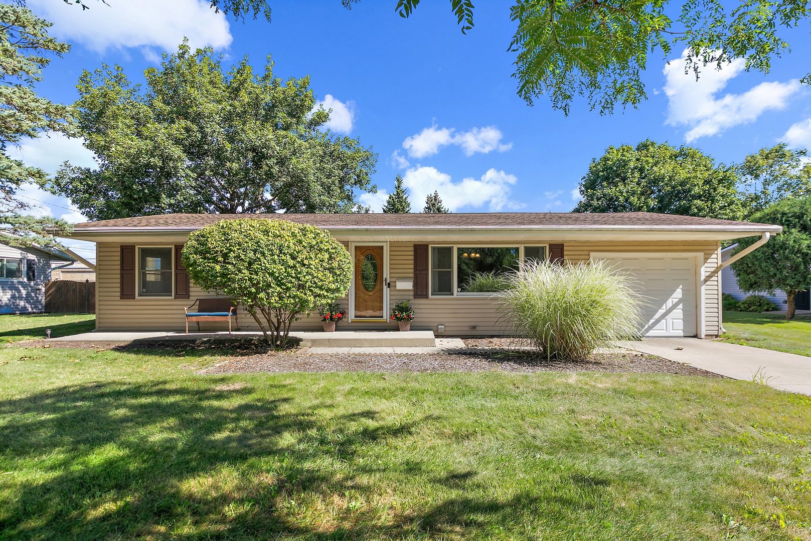 a front view of a house with a yard and potted plants