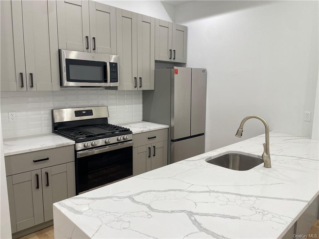 a kitchen with stainless steel appliances granite countertop a white stove top oven a sink and dishwasher