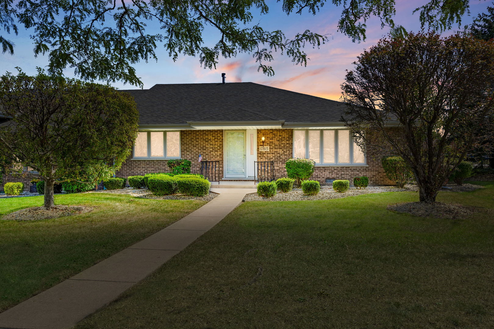 a front view of a house with a yard and potted plants