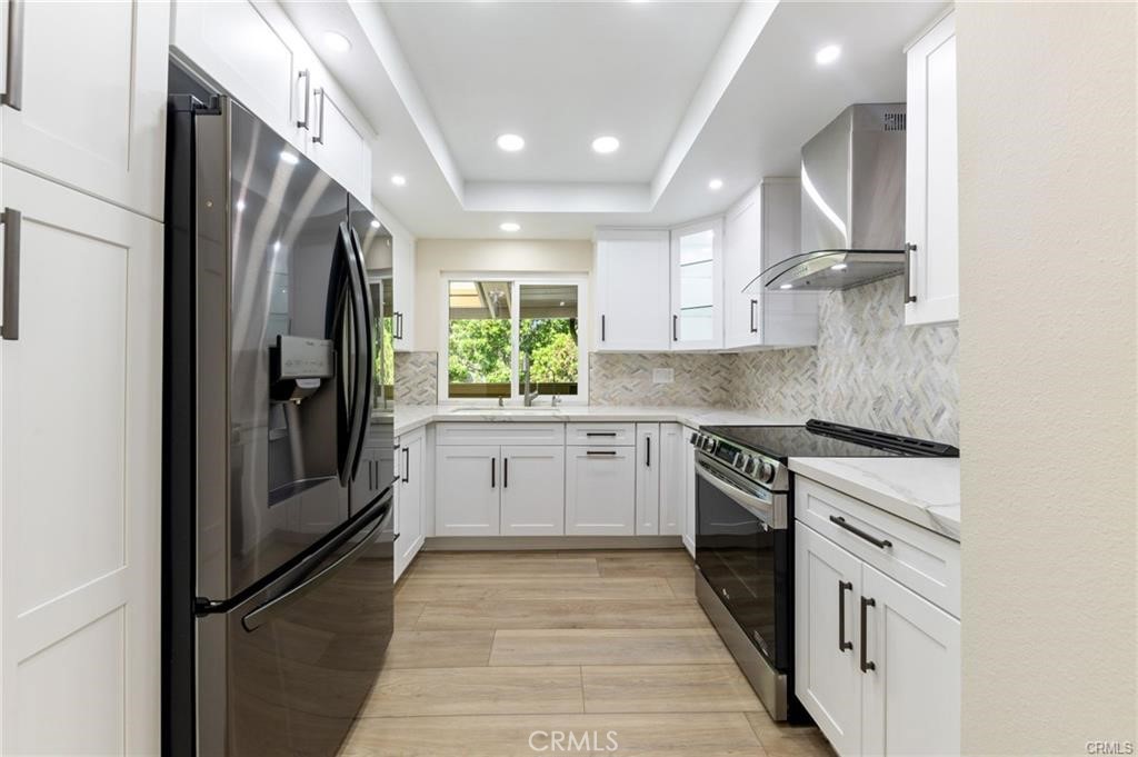 a kitchen with stainless steel appliances granite countertop a refrigerator and a stove