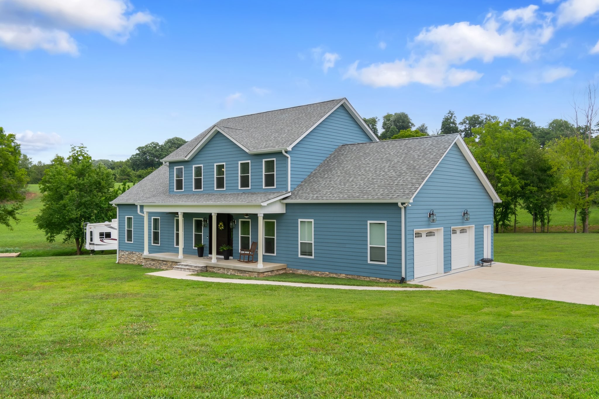 a front view of a house with yard and green space