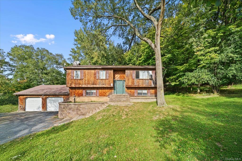 Raised ranch featuring a front yard and a garage