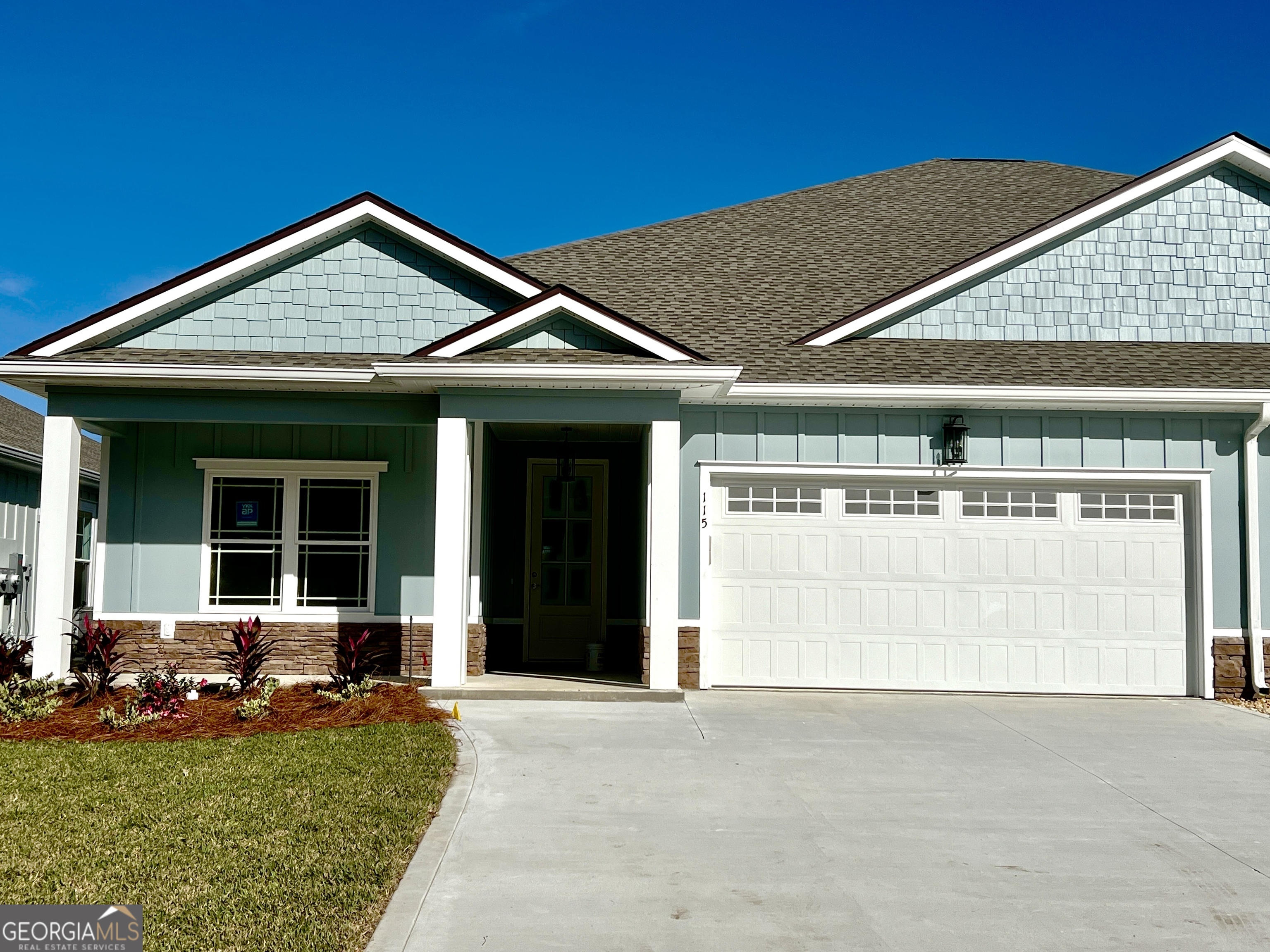 a front view of a house with a yard outdoor seating and garage