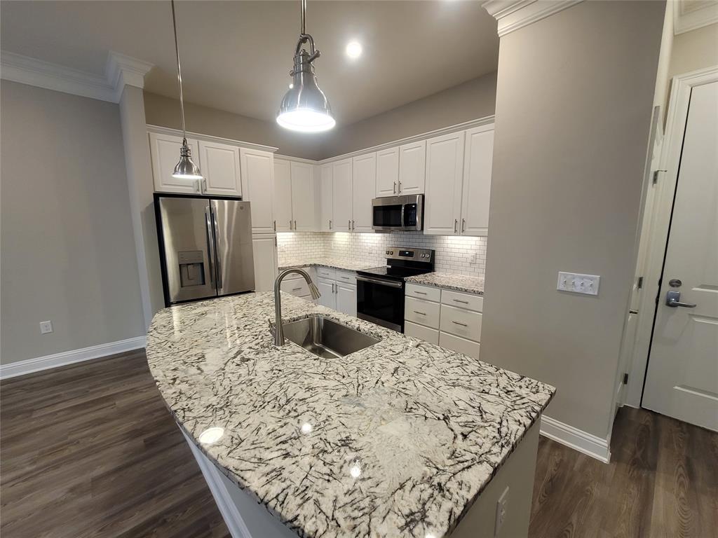 a kitchen with kitchen island white cabinets appliances and wooden floor