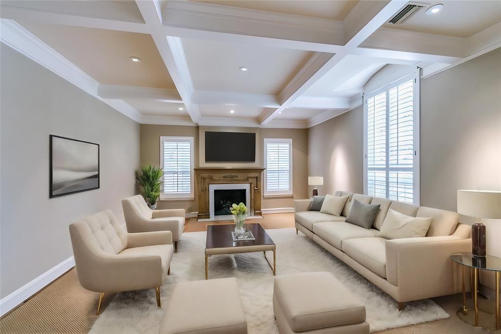 a living room with furniture a fireplace and a large window