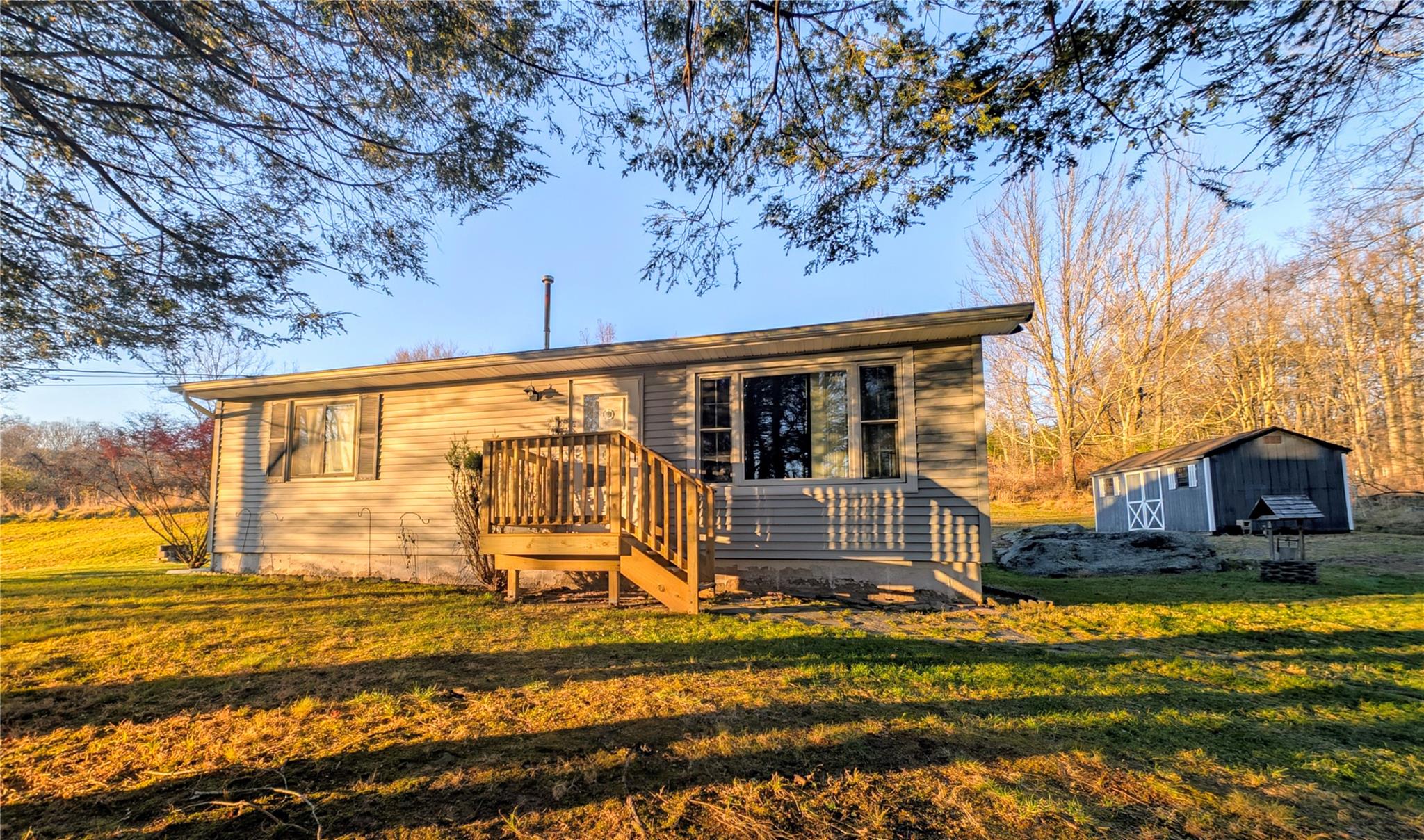 Rear view of house featuring a yard and a shed