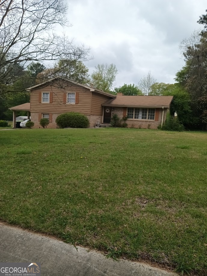 a view of a yard in front of a house with large trees