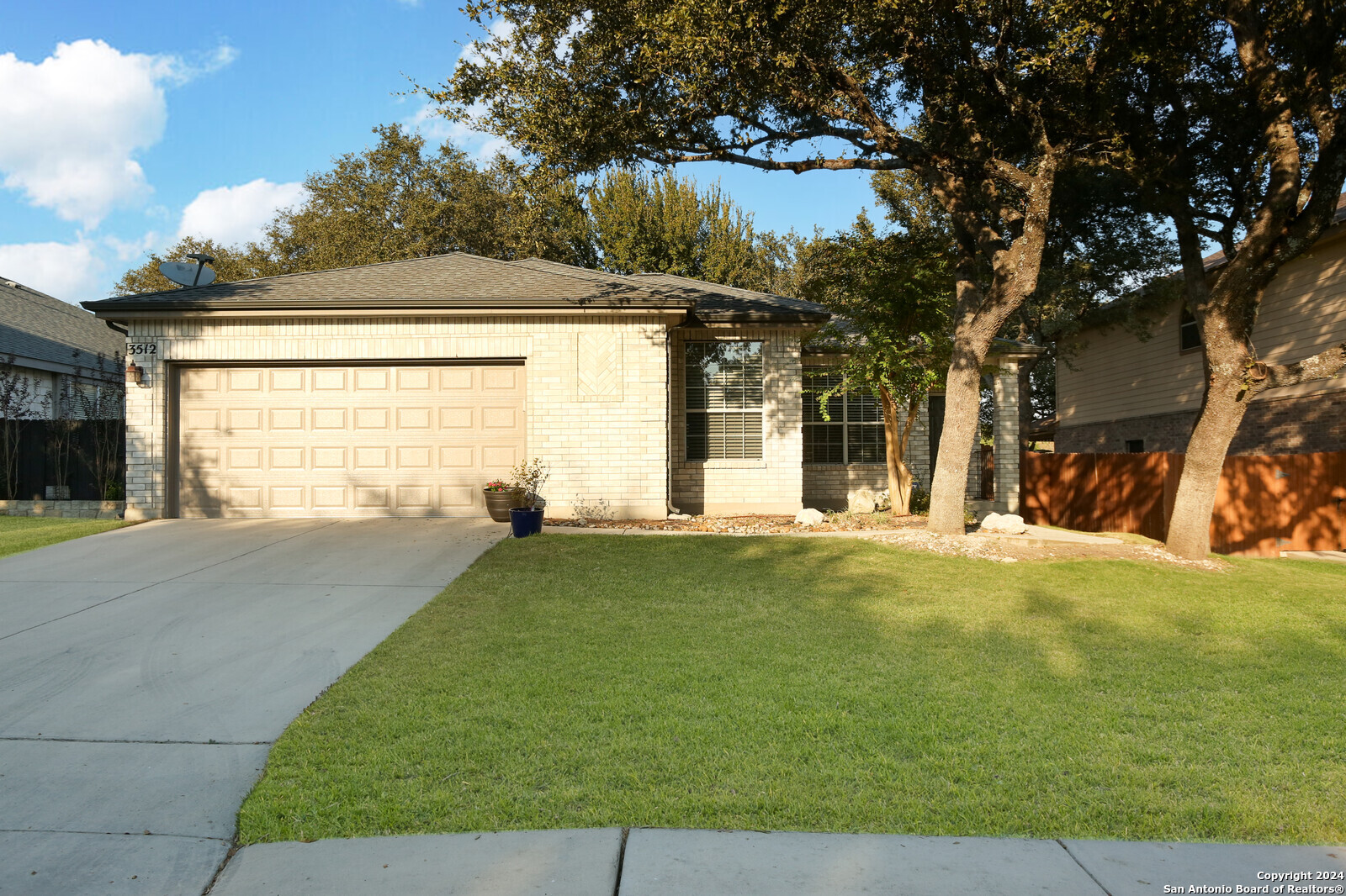 a view of a house with backyard and tree