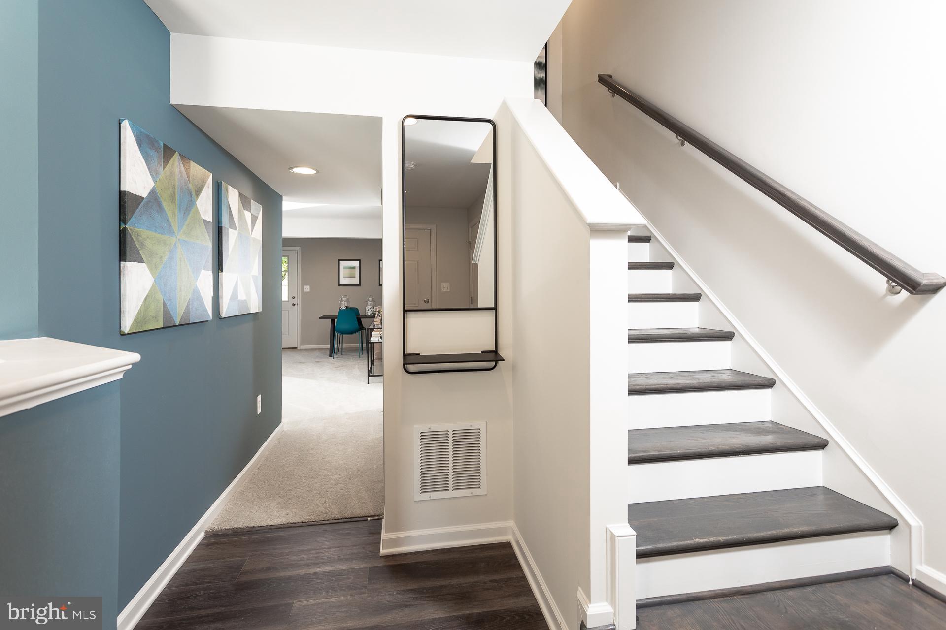 a view of a hallway with wooden floor and staircase