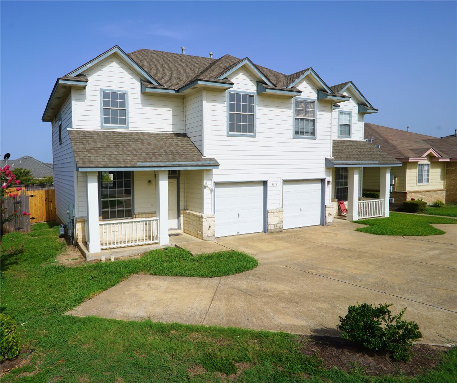 a front view of a house with a yard and garage