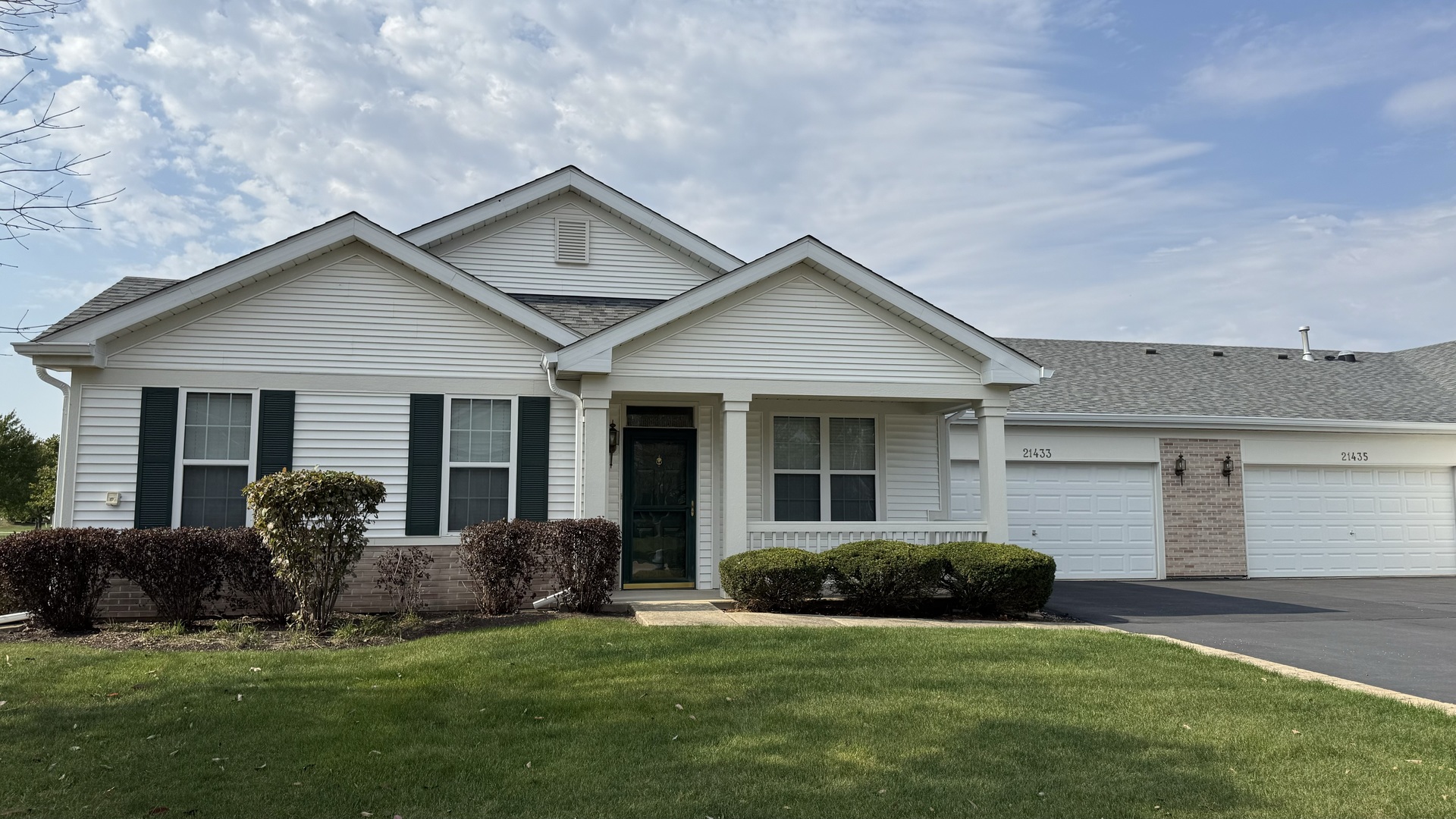 a front view of a house with a garden and yard