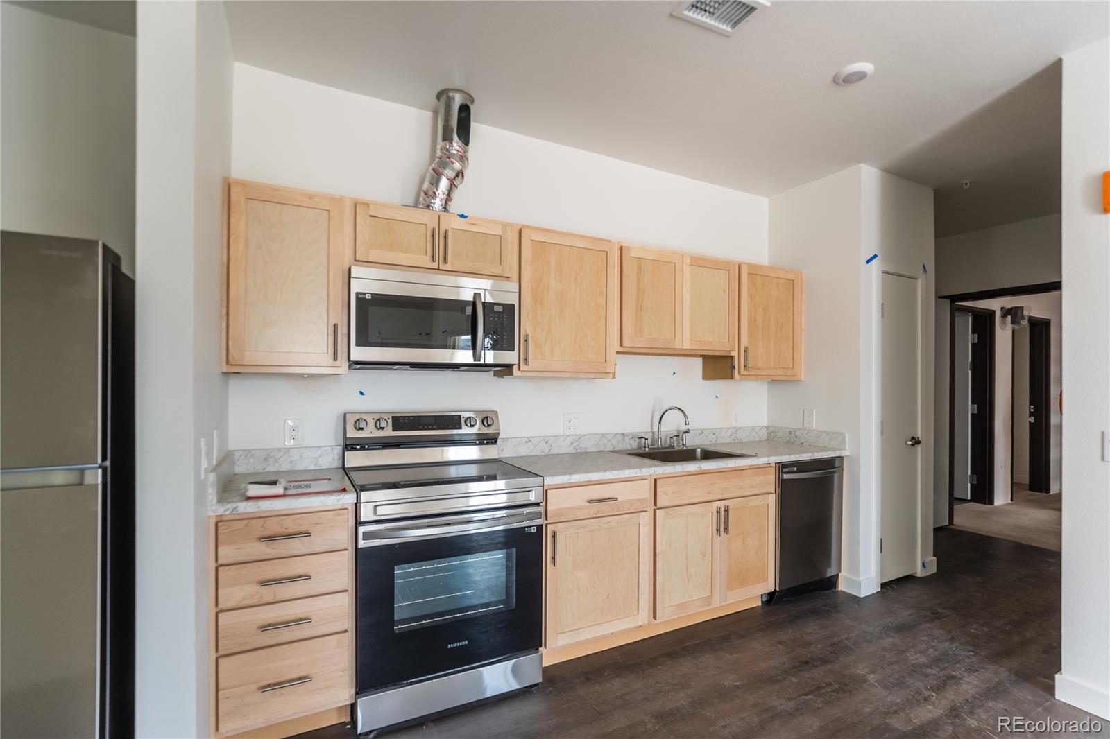 a kitchen with stainless steel appliances a stove microwave and refrigerator