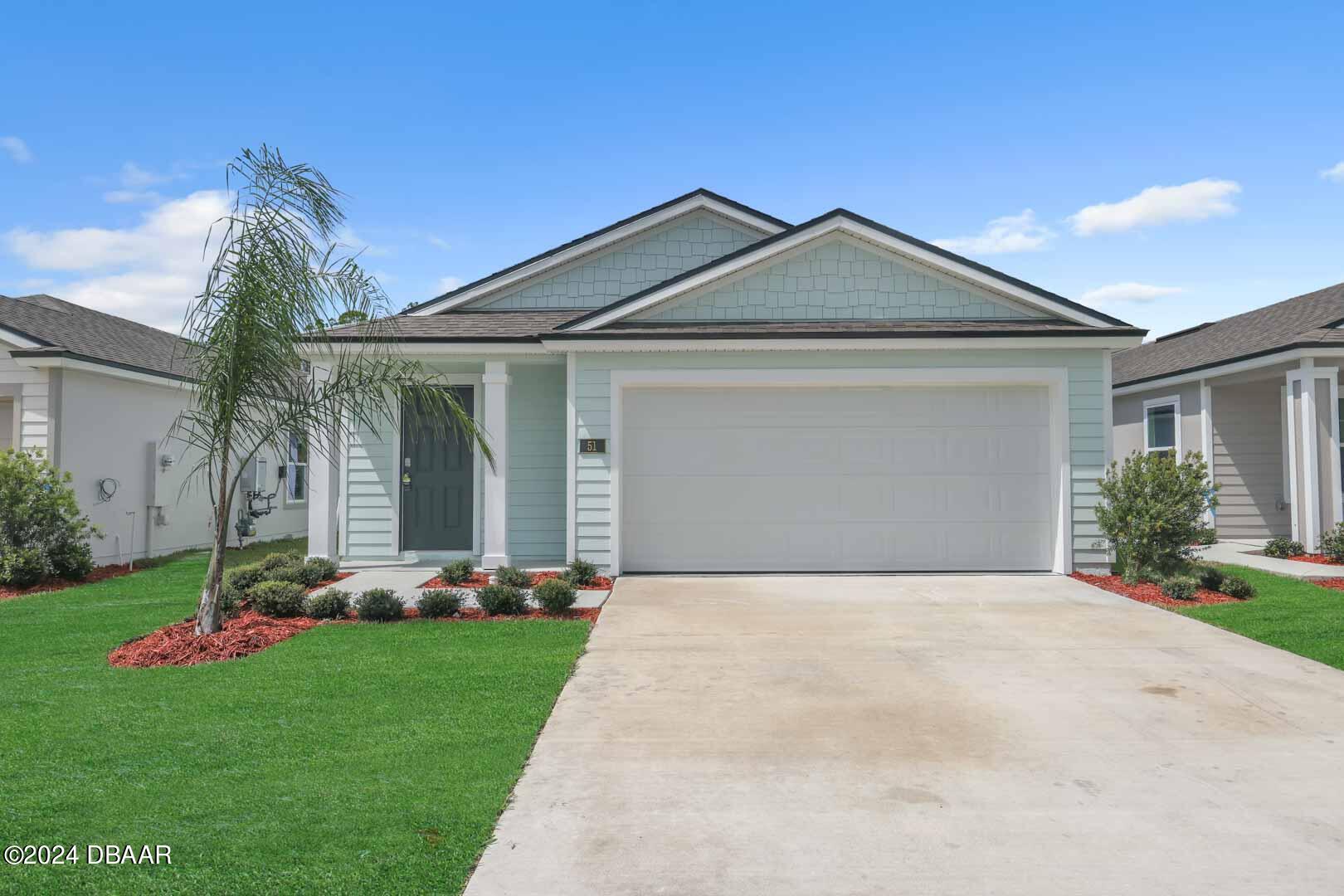 a front view of a house with a garden and plants