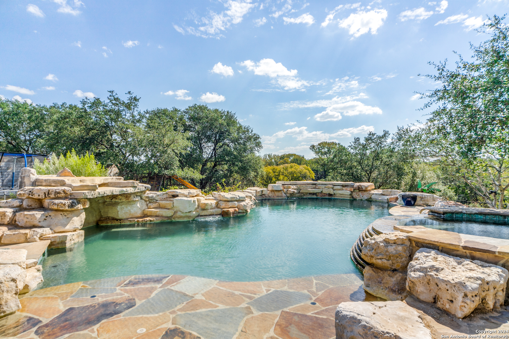 a view of a lake with lawn chairs and a fire pit