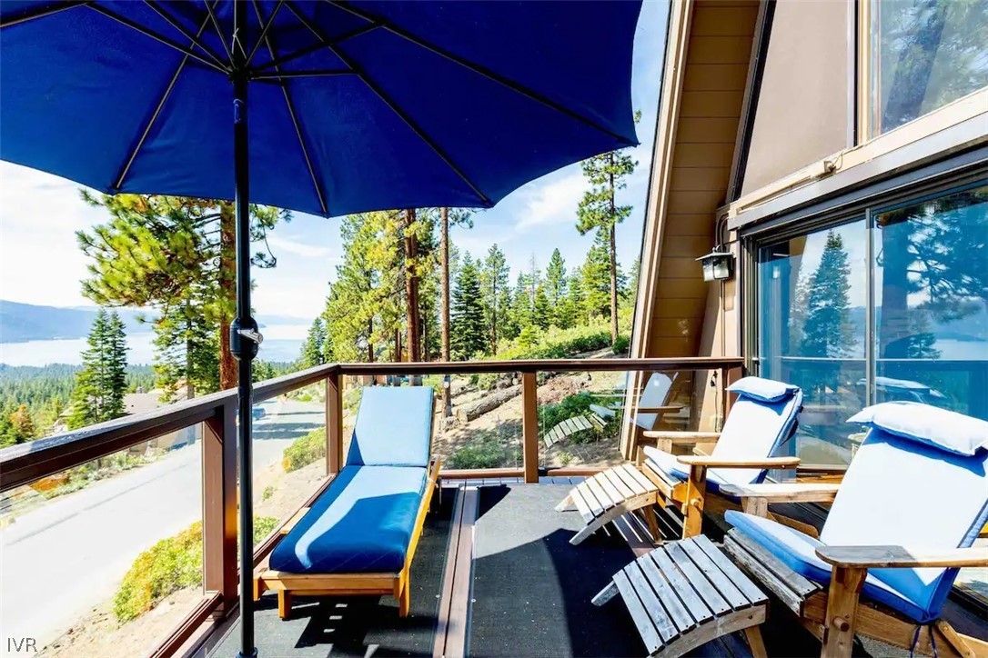 a view of deck with furniture and umbrella