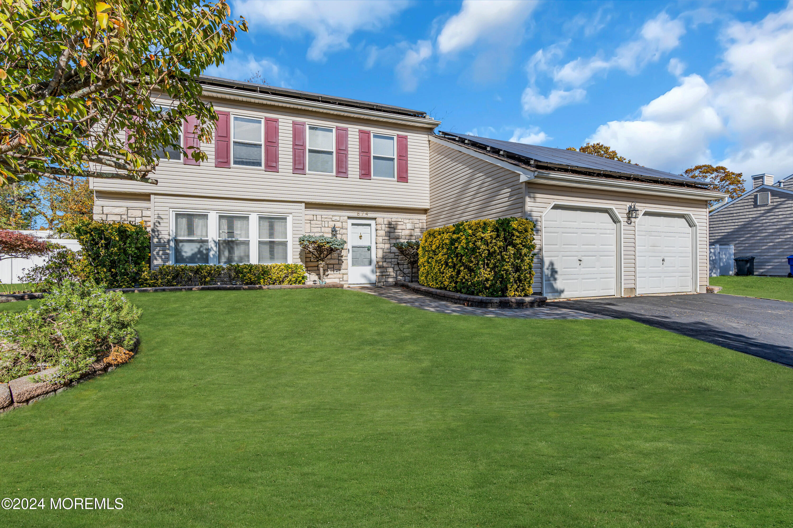 a front view of a house with a garden and plants