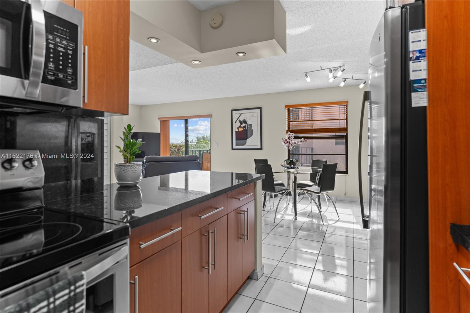 a kitchen with stainless steel appliances granite countertop a sink and a refrigerator