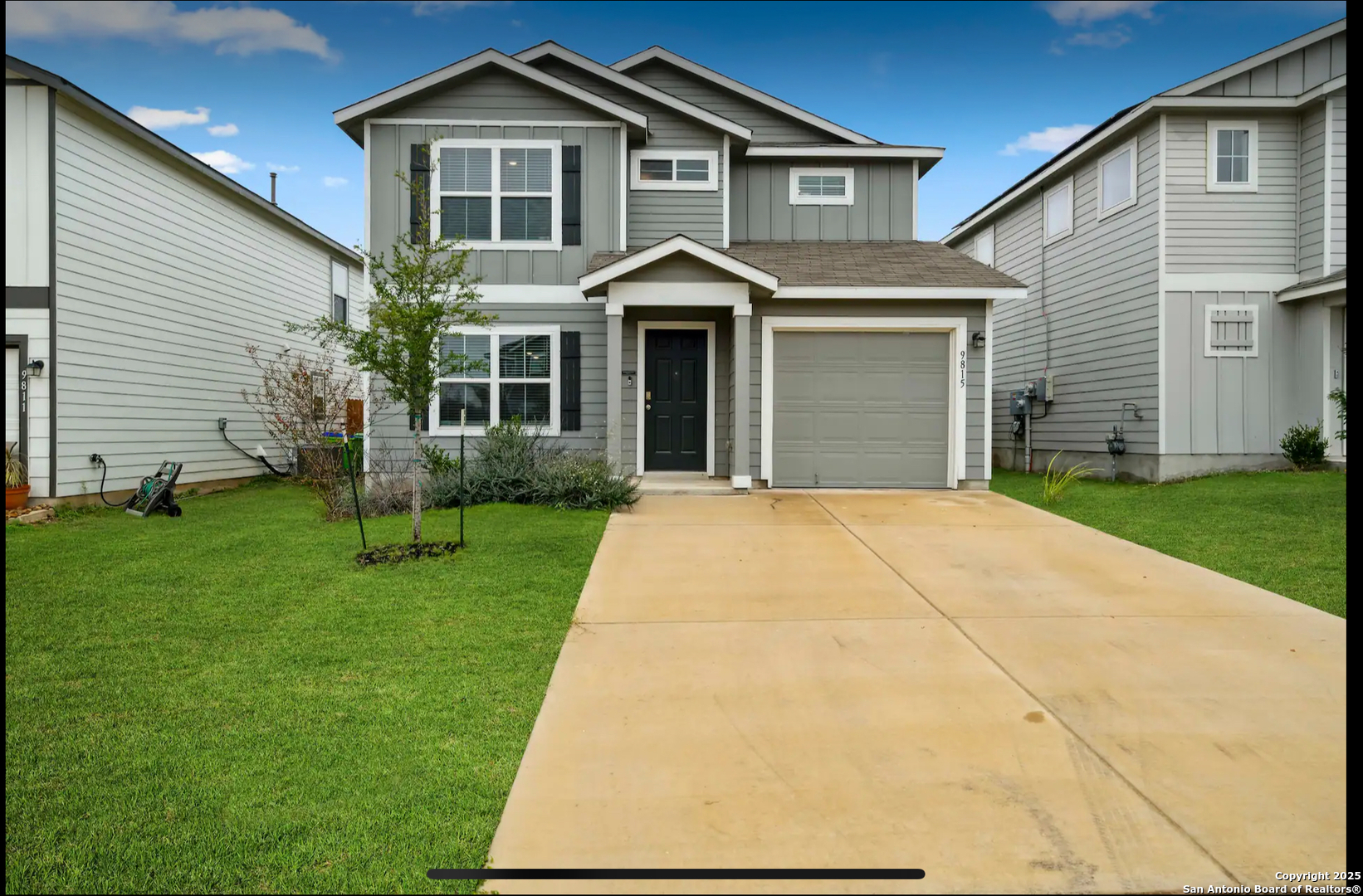 a front view of a house with a yard and trees