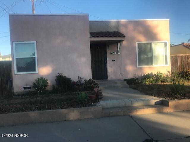 a front view of a house with plants