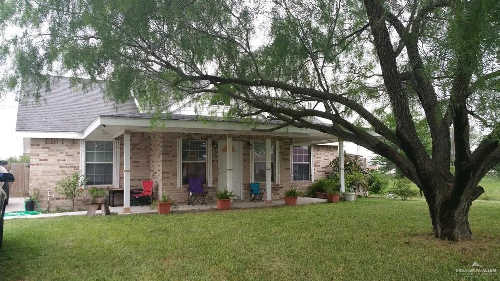 front view of a brick house with a yard