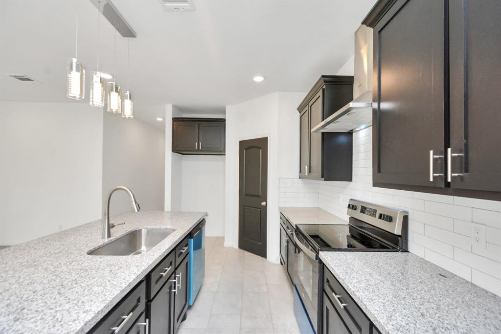 a kitchen with granite countertop kitchen island a sink stainless steel appliances and cabinets