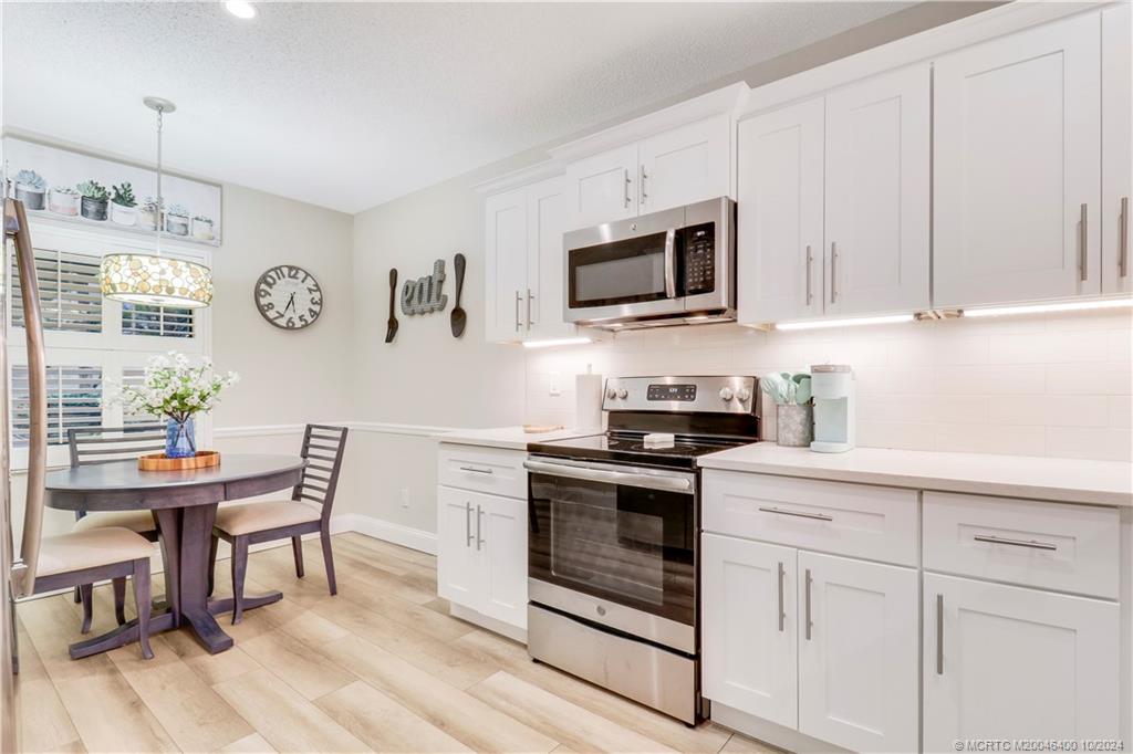 a kitchen with stainless steel appliances granite countertop a stove a sink and a microwave