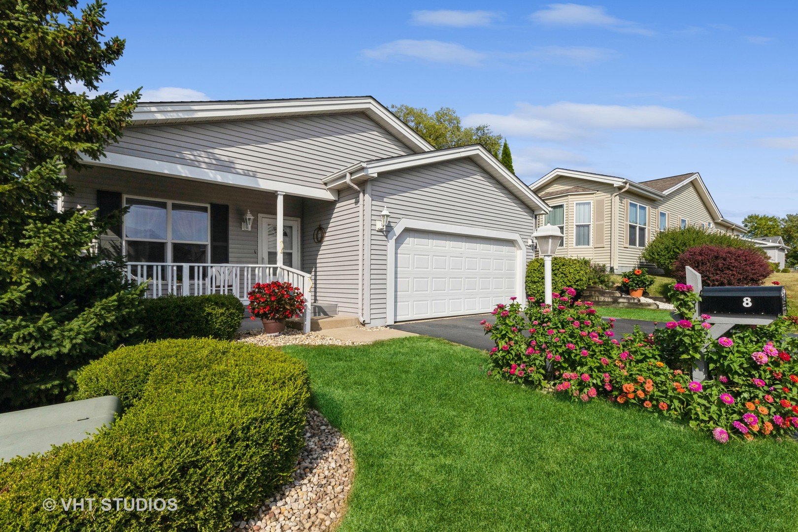 a front view of a house with a garden and plants