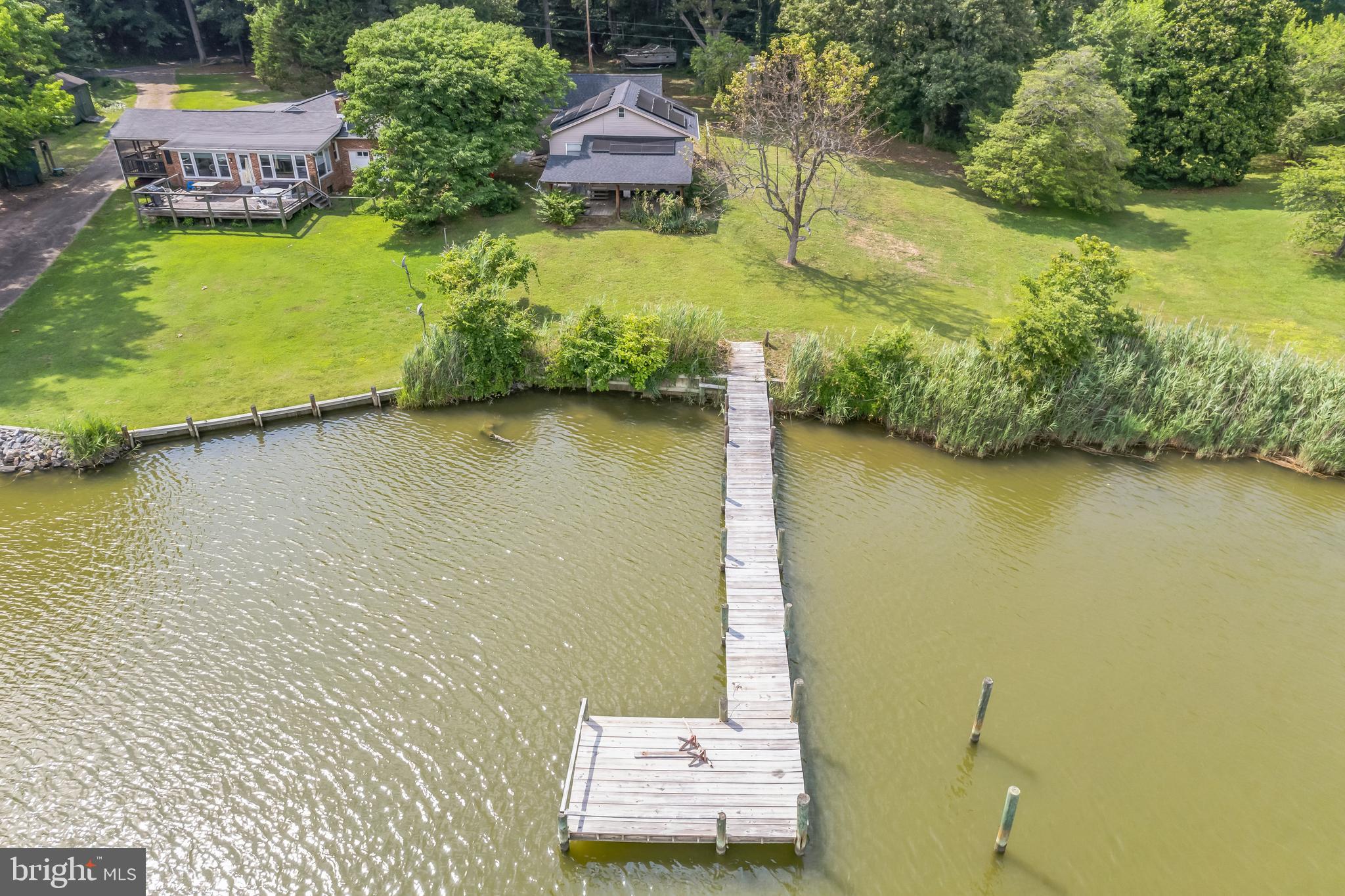 an aerial view of a house with a yard and lake view