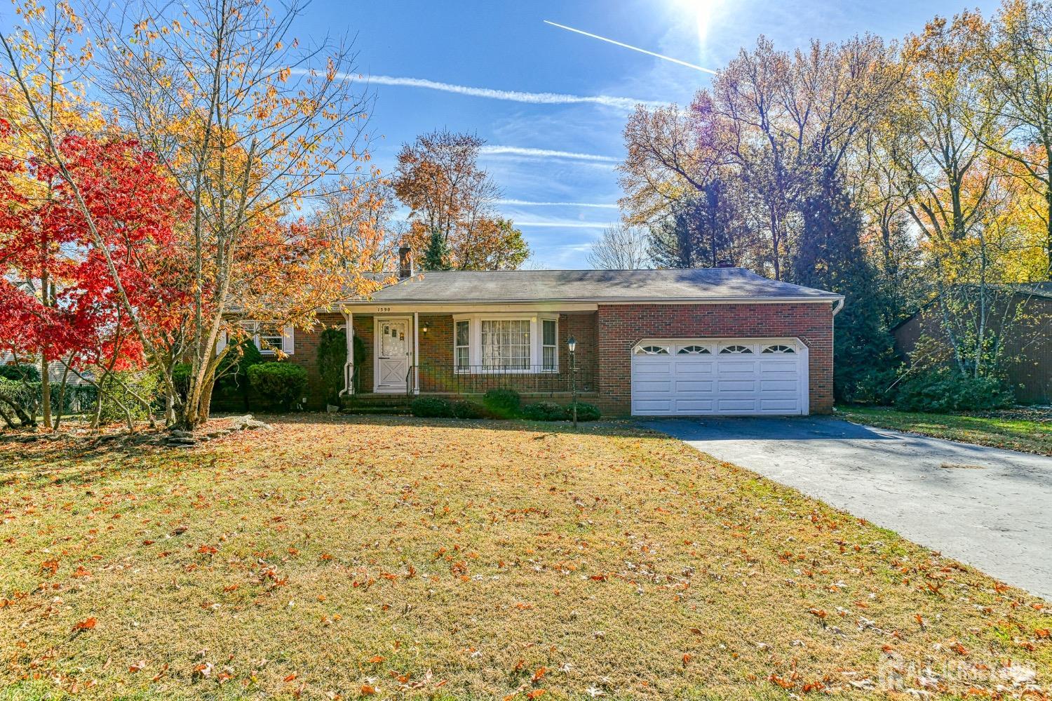 a front view of a house with a yard and trees