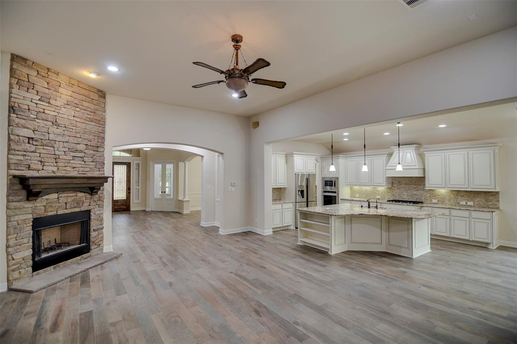 a view of kitchen with kitchen island wooden floor and fireplace