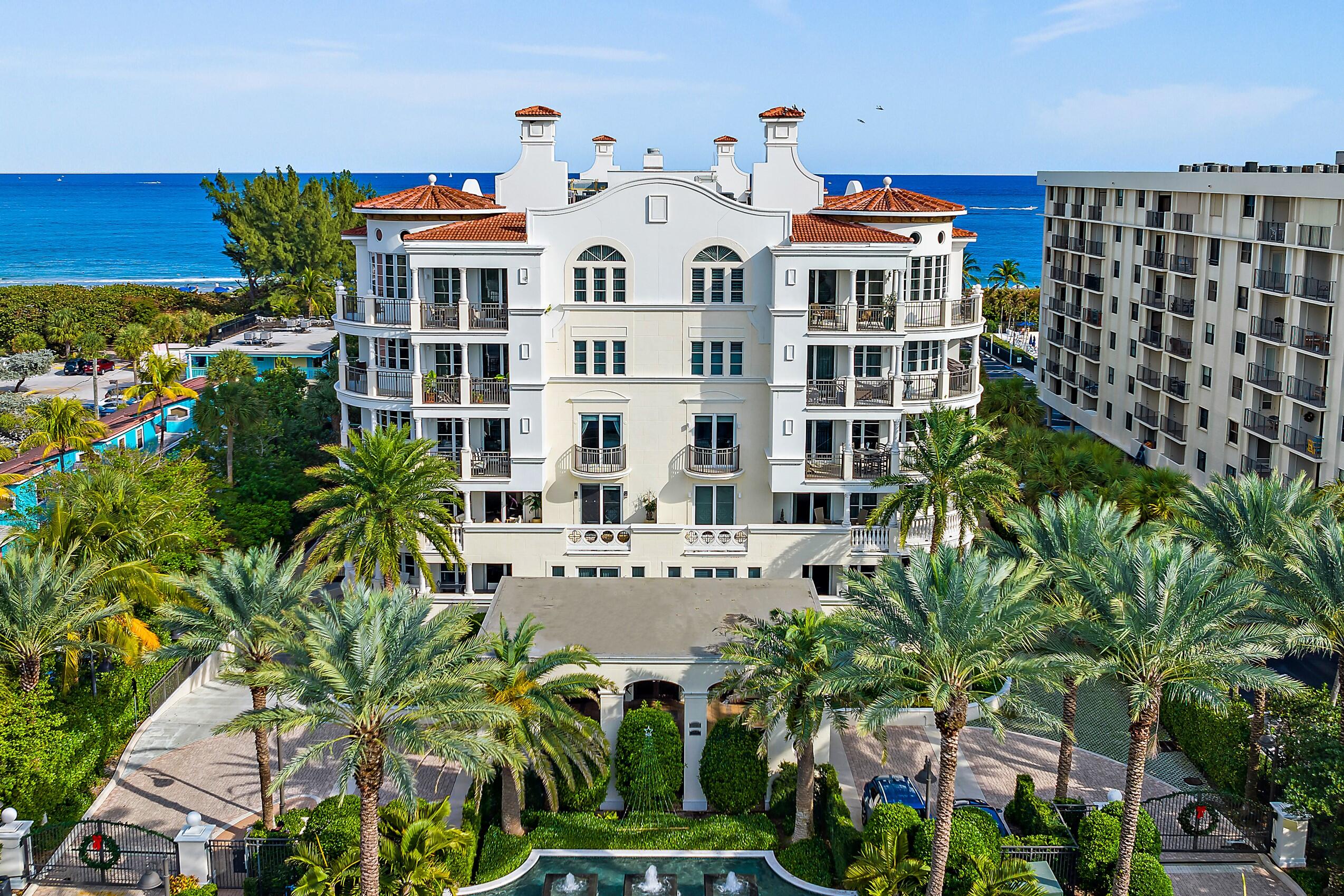 a front view of a building with balcony and garden