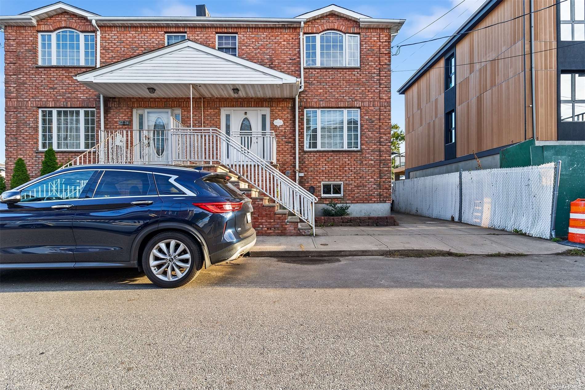 a front view of a house with parking space and a car parked